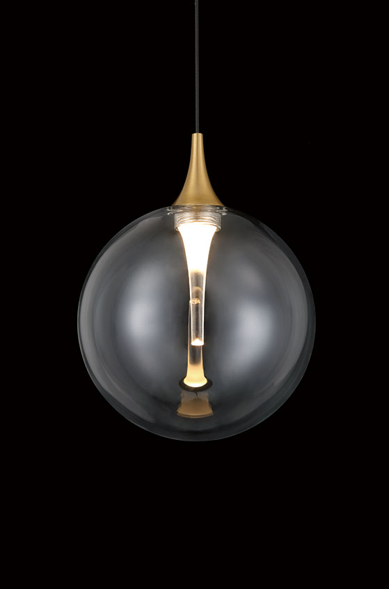 IISSA Gold pendant with clear glass globe illuminated against a dark background