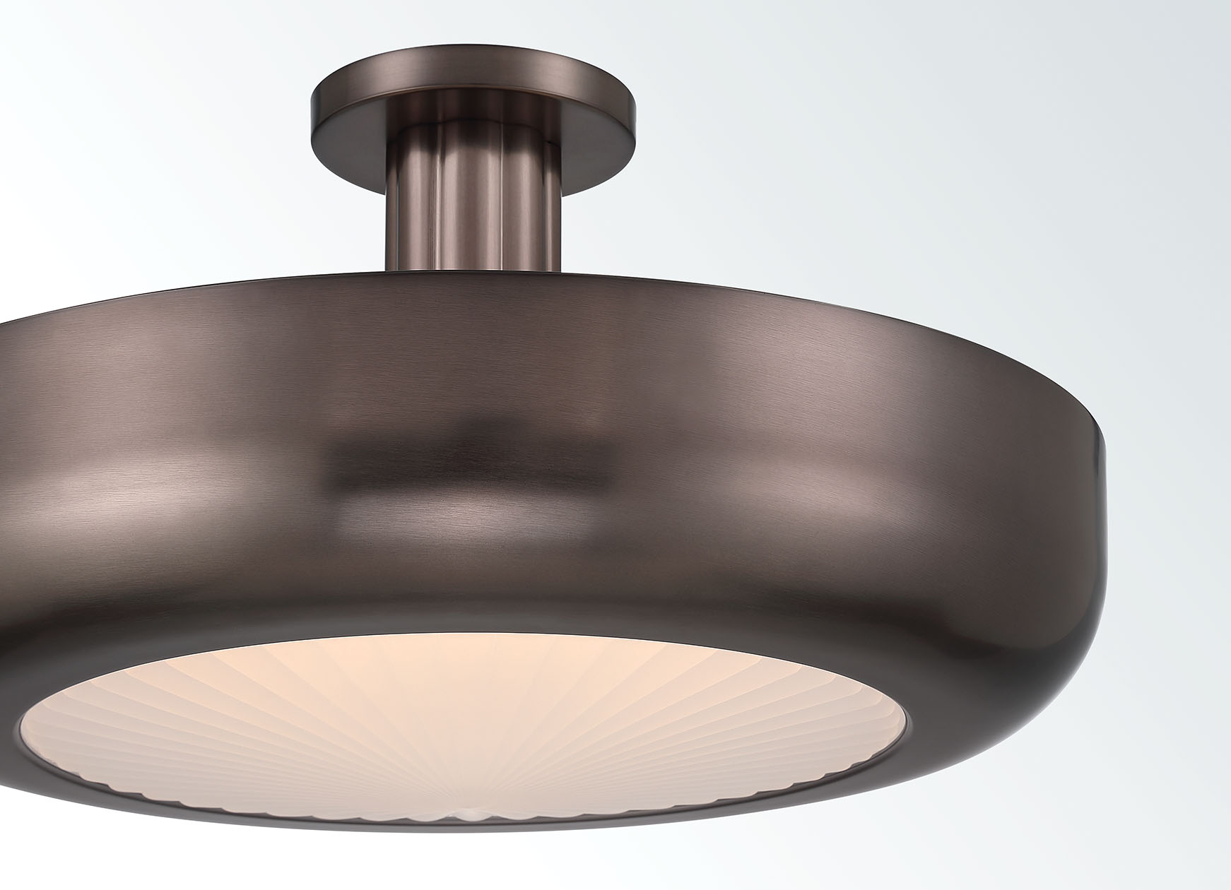 Macey bronze semi-flush mount with rounded metal body and softly illuminated pressed glass